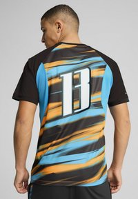Mustard, sinine ja oranž spordisärk, mille seljal on suur valge "13". Tekstureeritud kangas diagonaalsete triipudega ja lühikeste varrukatega.