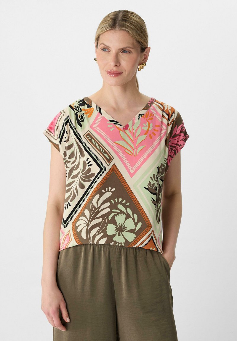 Kurzarmpullover mit V-Ausschnitt, der ein mehrfarbiges Blumenmuster zeigt, hauptsächlich in Pink, Grün, Braun und Schwarz auf einem hellen Hintergrund.