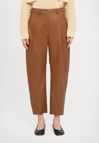 Pantaloni in finta pelle marrone con vita alta, taglio dritto e tasche frontali. Presenta una chiusura con un bottone e dettagli cuciti.