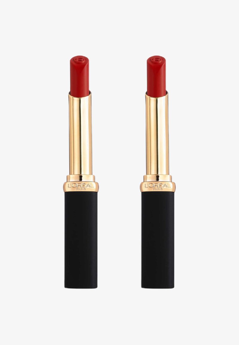 Deux rouges à lèvres avec un boîtier en métal doré brillant et une base noire mate. Les couleurs des lèvres sont un rouge éclatant avec une texture lisse.