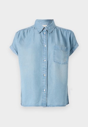 Camicia di jeans azzurra a maniche corte con bottoni davanti, colletto e taschino sul lato sinistro del petto. Tessuto morbido e vestibilità leggermente rilassata.