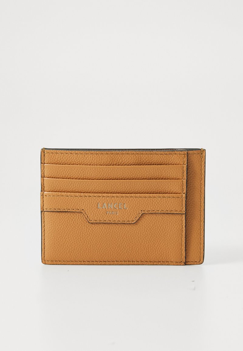 Tan leather cardholder with six card slots, textured surface, rectangular shape, and embossed brand logo on the front.