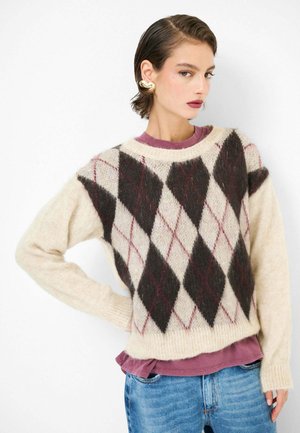 Maglione lavorato a maglia color crema con un motivo argyle scuro e diamanti color bordeaux. Morbida texture e vestibilità comoda, indossato sopra una camicia viola.