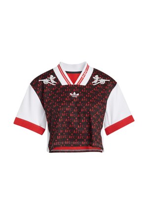 Černý, bílý a červený krátký sportovní dres s opakujícím se motivem "AFC", červenými pruhy na límci a logy s křídly a kanónem na hrudi.