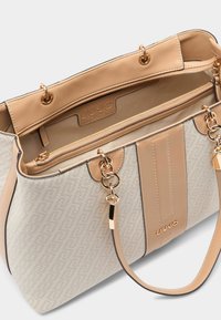 Sac fourre-tout beige avec un motif texturé, une quincaillerie dorée et deux anses. Comprend un compartiment zippé et un logo en relief à l'intérieur.