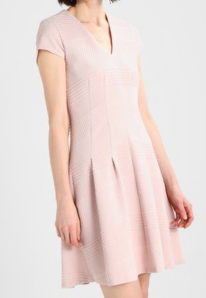 Robe rose clair avec un décolleté en V, des manches courtes, des motifs texturés et des plis au niveau de la jupe. Confectionnée dans un tissu extensible pour plus de confort.
