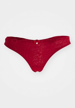 Rote Spitzenstring-Tanga mit floralem Muster und zarten Details. Verfügt über einen glatten Taillenbund und einen kleinen Akzentknopf auf der Rückseite.