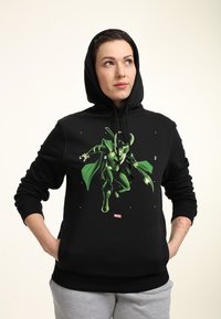 Sudadera negra con un gráfico verde de un personaje, que incluye capucha, puños acanalados y un bolsillo frontal. El material parece suave y grueso.