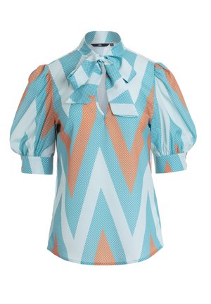 Niebieska i pomarańczowa bluzka w wzory z kropkami, z wysokim kołnierzem, detalem w postaci kokardy i bufianymi rękawami. Wykonana z lekkiego materiału.