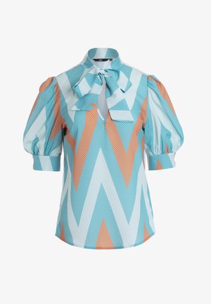 Niebieska i pomarańczowa bluzka w wzory z kropkami, z wysokim kołnierzem, detalem w postaci kokardy i bufianymi rękawami. Wykonana z lekkiego materiału.