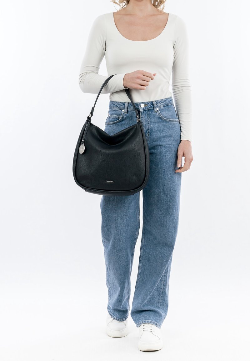 Sac hobo en cuir noir avec une texture douce, une forme arrondie et une anse supérieure unique. Comprend un tirette de fermeture éclair argentée et un logo discret.