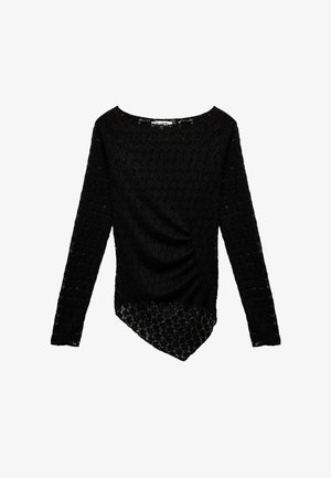 Haut noir à manches longues en dentelle avec un motif floral texturé, présentant un devant drapé et un ourlet asymétrique.