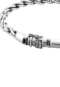 Silverfärgat armband med kedjelänkar som hakar i varandra, med polerad yta och ett lås med ingraverade detaljer. Mjuka, rundade kanter.