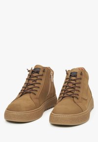 Bruine suède hoge sneakers met vetersluiting en zijrits, textuur rubberen zool, en een gewatteerde enkelband voor extra comfort.