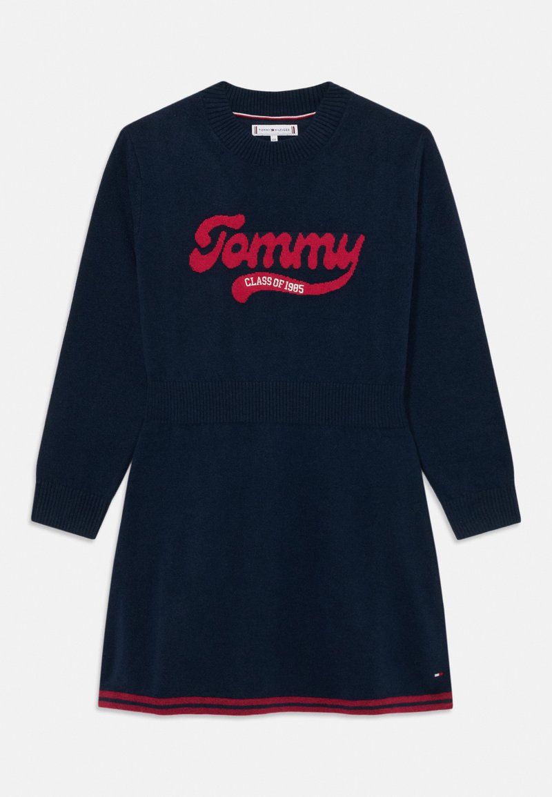Marinblå stickad klänning med långa ärmar och ribbade muddarna, utrustad med en röd "Tommy CLASS OF 1985" logotyp och en randig fåll.