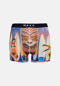 Boxers de bain avec un imprime tropical vif comprenant des planches de surf, un masque en bois sculpté et des accents colorés. Ceinture élastique noire avec le logo 'WAXX'.