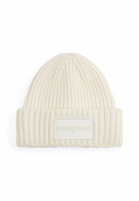 Beanie lavorato a maglia di un crema chiaro con texture a coste. Presenta un risvolto e una patch con "tommy jeans" in una tonalità oro chiaro.