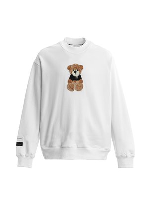 Sudadera blanca de manga larga con un osito de peluche marrón con una camiseta negra bordada en el pecho y una pequeña etiqueta en el puño izquierdo.