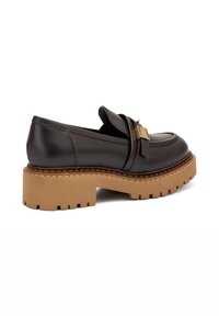 Mocassini in pelle marrone scuro con una suola platform in materiale beige spesso e dalla texture lavorata. Presentano una fascia decorativa e hardware in oro.