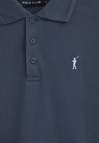 Granatowa koszulka polo z fakturowanej tkaniny, z trzema guzikami, i haftowanym jasnoniebieskim logo golfisty na lewej piersi.