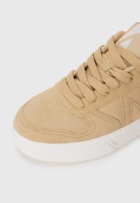 Matalaami low-top kengät, valmistettu teksturoidusta mokasta ja verkosta, joissa on pyöreät nauhat, pehmustettu kaulus ja valkoinen kumipohja, jossa on kuvioitu pito.
