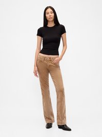 Brown corduroy flared pants with ribbed texture and front pockets, paired with a black fitted short-sleeve t-shirt and black heeled boots.