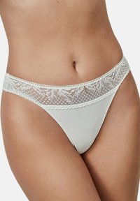 Witte stringonderbroek met een kanten tailleband met bladvormen en gekartelde randen, een gladde textuur en een getailleerd ontwerp.