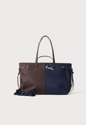 Sac fourre-tout bicolore avec des parties marron et bleu marine, des poignées marron foncé et une décoration argentée "Lola" sur le côté bleu marine.