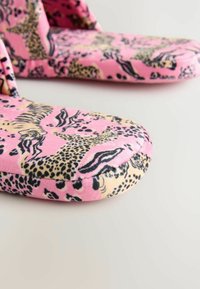 Růžové skluzavkové pantofle s leopardím vzorem v černé a béžové barvě, vyrobené z měkké tkaniny s polstrovanými podrážkami pro pohodlí.