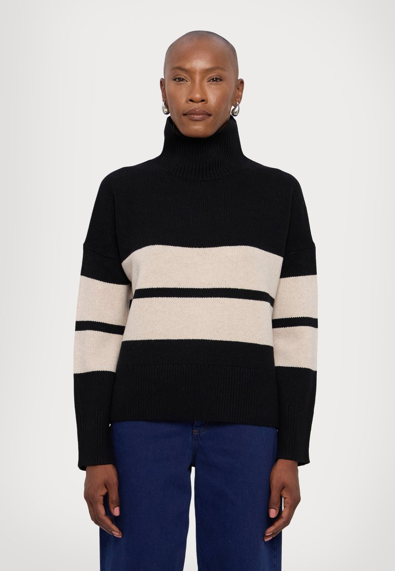 Black and beige striped sweater with a high turtleneck, ribbed cuffs, and a loose fit. Soft texture with contrasting horizontal stripes.