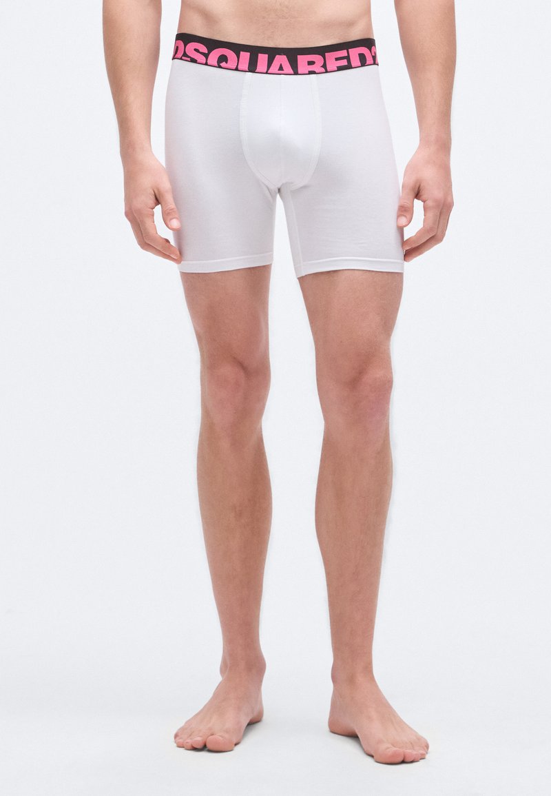 Calzoncillos bóxer blancos con una cintura con logo en negro y rosa, que ofrecen un ajuste ceñido y una textura de tela suave.