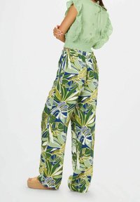 Pantalons larges à imprimé floral en vert, bleu et jaune. Tissu léger, taille élastique et cordon de serrage.