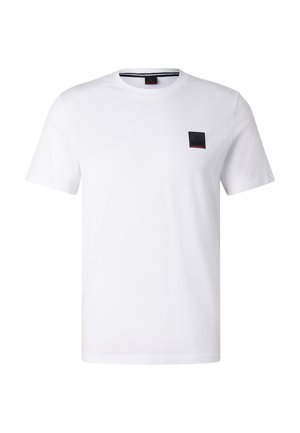 Biała koszulka z krótkim rękawem i okrągłym dekoltem, z małą czarną prostokątną naszywką z logo na lewej piersi.