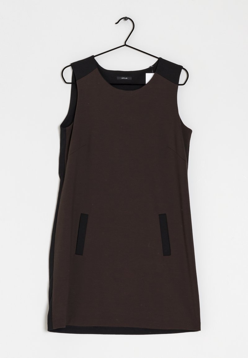 Robe marron foncé sans manches avec des accents noirs aux épaules et deux fentes verticales noires pour poches, suspendue à un cintre noir sur fond blanc.