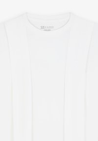 T-shirt bianco in cotone con scollatura rotonda e texture morbida. Presenta dettagli sottili nei pannelli laterali per un interesse di design aggiuntivo.