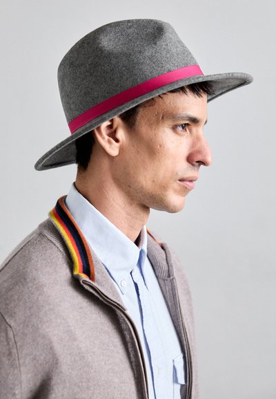Gray felt hat with a pink ribbon band, featuring a wide brim. The person wears a light blue shirt with a multicolored striped collar.
