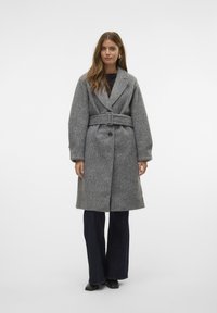 Manteau gris en mélange de laine avec un col cranté, une taille ceinturée et deux poches avant. Présente des manches larges et une fermeture à boutons.
