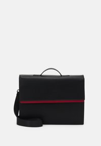 Sort lædertaske med klaplukning, udstyret med en rød vandret stripe og en aftagelig skulderrem. Glat tekstur med minimal hardware.