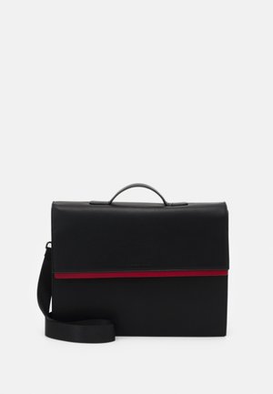 Zwarte leren tas met een klepsluiting, voorzien van een rode horizontale streep en een afneembare schouderband. Gladde textuur met minimale hardware.