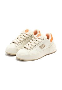 Sneaker color crema con accenti arancioni, dotate di una tomaia testurizzata, chiusura con lacci e una spessa suola in gomma con battistrada a disegno.