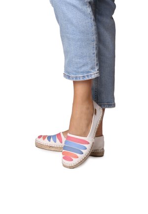 Leinenschuhe mit einer gewebten Jutesohle, mit einem weißen Grund und bunten, pinken und blauen, geschwungenen Mustern auf dem Obermaterial.