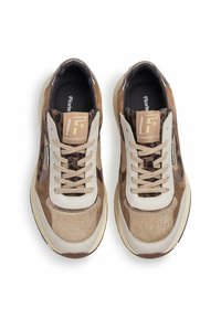 Sukan dengan skema warna coklat dan beige, menampilkan kain bermotif dan aksen kulit, ujung bulat, dan tali yang bercorak.