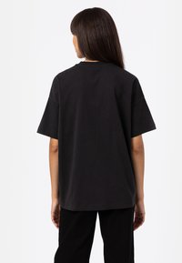 Black cotton t-shirt with short sleeves and a relaxed fit. Features a crew neck and a plain, smooth texture. No visible graphics or accents.