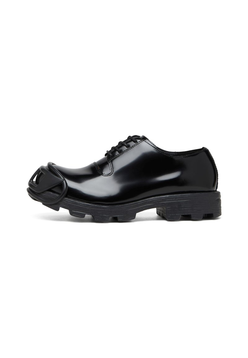 Chaussure en cuir verni noir avec une finition lisse, présentant des accents en caoutchouc noir uniques à l'extrémité et une semelle texturée robuste.