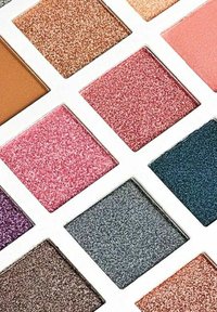 Palett av ögonskuggor med 12 fyrkantiga behållare i olika nyanser, inklusive glittrig rosa, brons, lila och djup teal finish.
