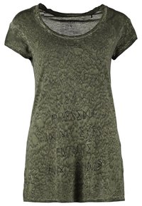 Camiseta verde oliva con cuello redondo, mangas cortas y tejido texturizado. Presenta texto negro bordado en la parte frontal.