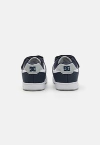 Baskets bleu marine avec une texture lisse, dotées d'accents blancs sur la semelle et le talon, ainsi qu'un logo à l'arrière. Design basse avec lacets.