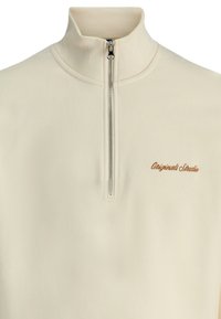 Pull en crêpe crème à demi-zippé, avec un col côtelé, une fermeture éclair argentée et le logo "Originals Studio" en fil marron sur la poitrine.