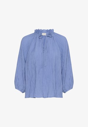 Gaiši zila blūze ar saplacinātu kaklu, garajām pūkainajām piedurknēm un strukturētām vertikālajām svītrām. Iezīmēta ar saišu aizdari un pogu akcentiem.