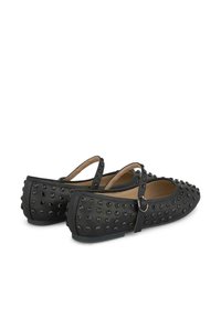 Bailarinas negras hechas de material suave, con tachuelas metálicas redondas y una correa con hebilla. Diseño de puntera redondeada y suela plana.